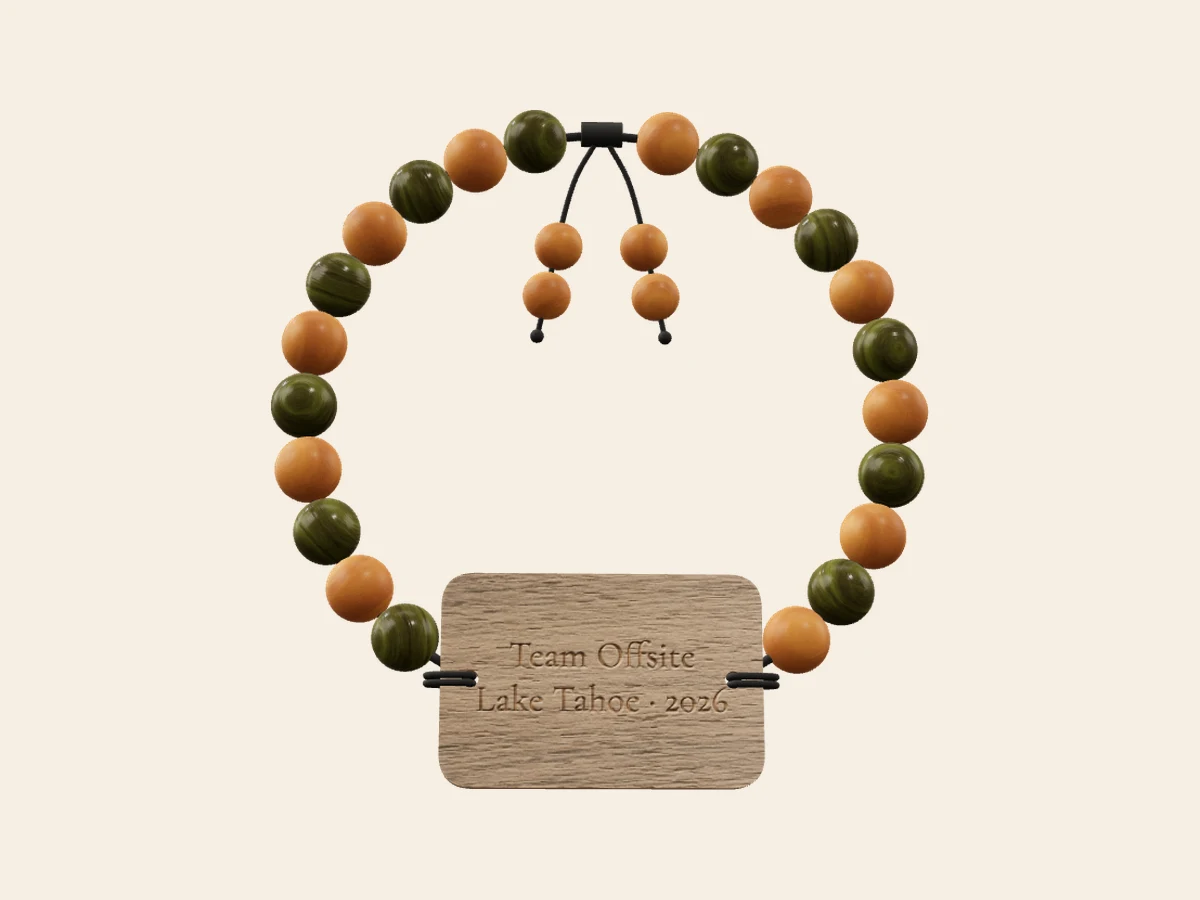Team Offsite — Honey sandalwood and green ebony on a walnut rounded-rectangle tag. Rendered in the Wearable Events 3D designer.